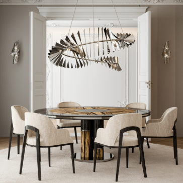 A modern dining room features a round black and gold table with five cream-colored, cushioned chairs. A unique spiral chandelier hangs above the table alongside a Contemporary Twisted Polished Nickel Wall Light. The room has neutral-toned walls, minimalistic decor, and white double doors in the background.