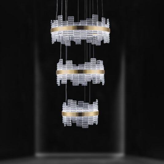The Large Modern Tiered Venetian Glass Chandelier features three horizontal, gold-colored rings, each adorned with intricate Venetian glass pieces. The tiered rings are suspended in mid-air by slim, vertical wires and illuminated in a dark room, creating a striking and elegant appearance.