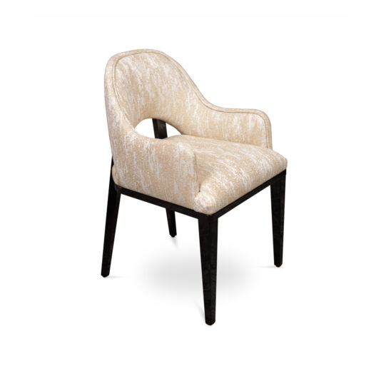 A modern chair with light beige, textured fabric upholstery and a cutout on the backrest. The chair features dark wooden legs and armrests that curve slightly for added comfort. When paired seamlessly with the Luxury Round Ebony Veneer Dining Table Set, the overall design exudes a sleek and contemporary aesthetic.