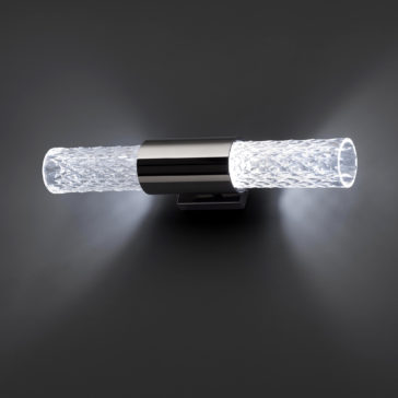 Modern Faceted Crystal Wall Light The Modern Faceted Crystal Wall Light includes two cylindrical, textured glass shades flanking a central metallic mount. It casts a soft, white glow from both ends against a dark background.