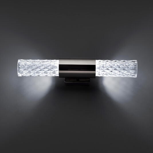 Modern Faceted Crystal Wall Light The Modern Faceted Crystal Wall Light features a metallic central base and textured glass tubes that emit bright white light from both ends. The contrast against the dark background enhances its sleek and contemporary appearance.