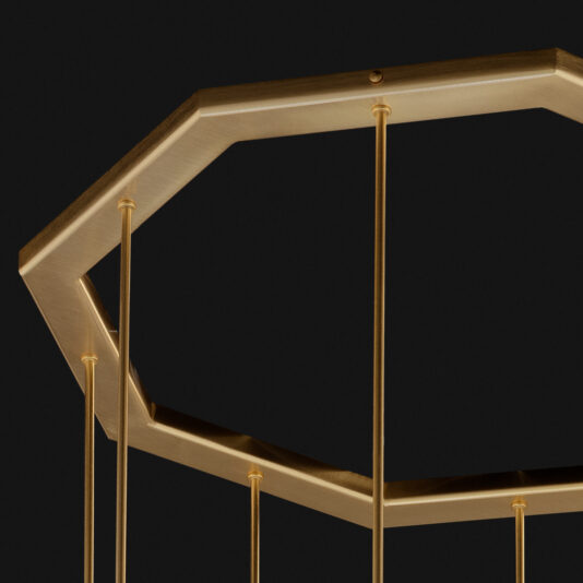 A close-up of the Modern Geometric Pendant Style Chandelier's frame, showcasing its modern and minimalistic design against a black background. Thin gold rods extend downward from each corner of the octagonal shape, emphasizing its contemporary aesthetic.