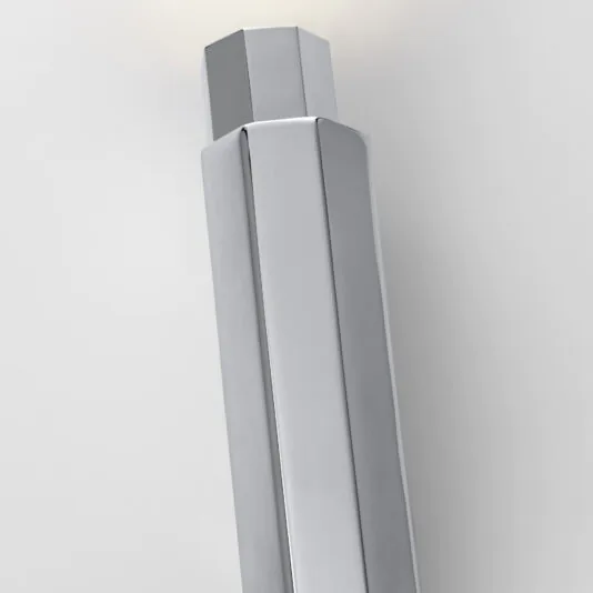 Close-up of a sleek, modern, shiny metallic Modern Geometric Tube Style Wall Light with a hexagonal barrel and a rounded top, evoking the refined elegance of modern geometric design, photographed from a top-side angle against a clean, white background.
