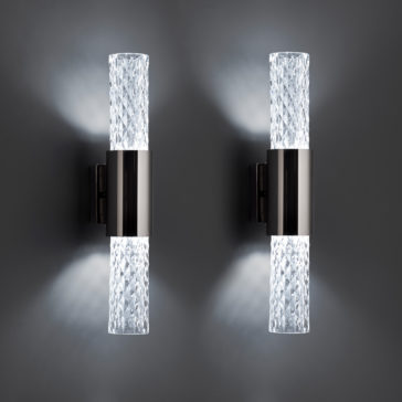 Modern Vertical Faceted Crystal Wall Light Two Modern Vertical Faceted Crystal Wall Lights are mounted side by side on a gray wall. Each sconce emits bright, cool white light from the top and bottom, creating an elegant and symmetrical lighting effect.