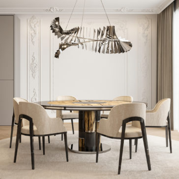 An elegant dining room features a modern chandelier, pristine white ornate walls, and a round wooden table surrounded by six Modern Art Deco Style Tub Dining Chairs upholstered in beige. The setup rests on a light-colored carpet, while large windows with sheer curtains allow natural light to flood the space. The minimalist yet chic decor perfectly embodies the Modern Art Deco style.