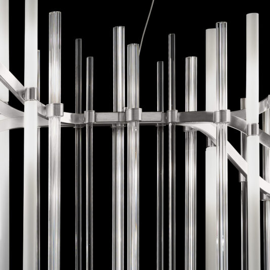 Introducing the Vertical Murano Glass Tube Chandelier, a contemporary lighting fixture that boasts numerous vertically arranged glass rods connected by metallic supports against a black backdrop. The sleek, cylindrical rods vary in height, adding to its modern and stylish appeal.