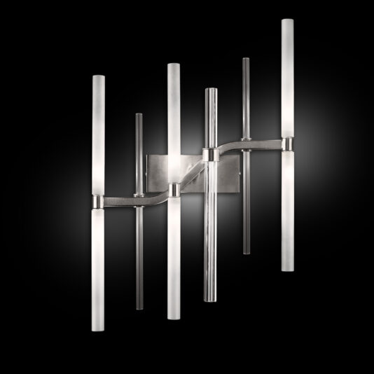 The Vertical Murano Glass Tube Wall Light is a contemporary wall sconce showcasing an elegant design. It features multiple cylindrical glass tubes arranged at different heights on a polished metallic base set against a black background. The light tubes produce a soft, diffused glow.