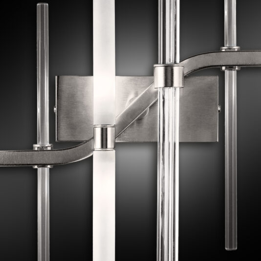 Vertical Murano Glass Tube Wall Light A close-up image of the Vertical Murano Glass Tube Wall Light. The fixture features sleek, vertical Murano glass tubes connected to a central rectangular metal base with horizontal metal arms, creating a minimalist and contemporary design against a dark background.