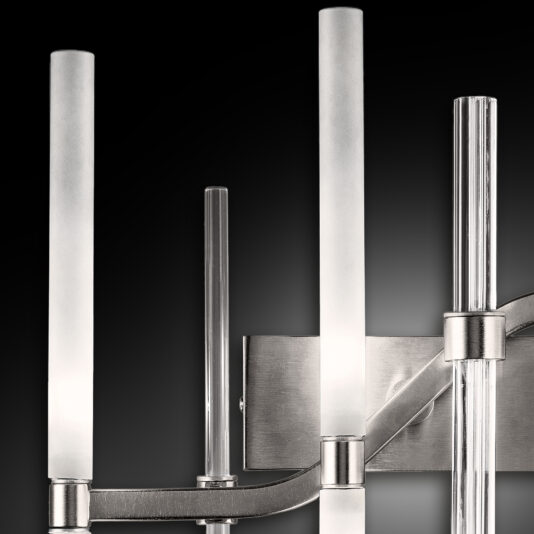 Vertical Murano Glass Tube Wall Light The Vertical Murano Glass Tube Wall Light features multiple vertical Murano glass tubes of varying heights, mounted on a brushed metal base. Against a dark background, it emits a soft, diffused light that enhances its sleek and contemporary aesthetic.