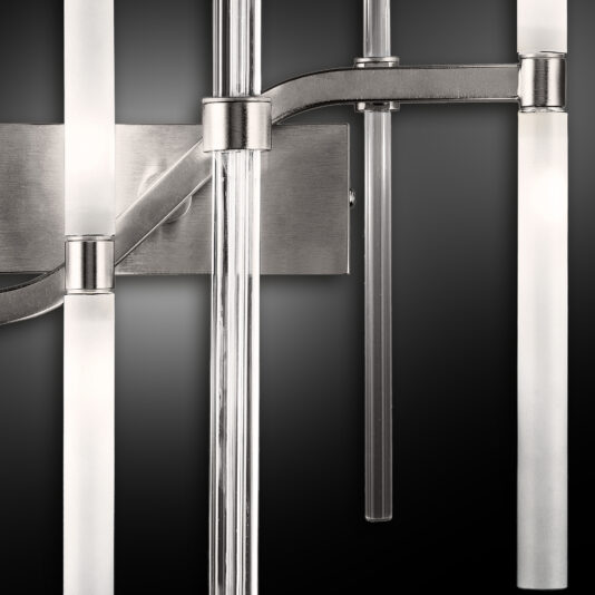 Vertical Murano Glass Tube Wall Light Close-up of the Vertical Murano Glass Tube Wall Light, showcasing its modern design with multiple illuminated cylindrical glass rods and metallic accents against a dark background. The glowing light rods beautifully highlight its sleek and contemporary aesthetic.