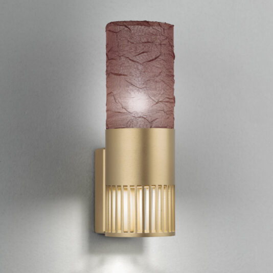 Modern Single Wall Light With Shade The Modern Single Wall Light With Shade showcases a contemporary cylindrical design. The upper portion is adorned with a textured purple shade, while the lower half boasts a sleek gold finish with vertical slits at the base, letting light filter through beautifully.
