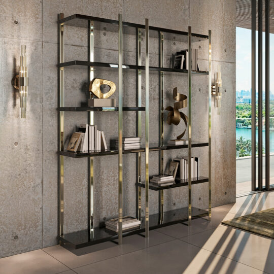 A modern living room has the Large Modern Open Bookcase with sleek metal and glass shelves against a textured concrete wall. Abstract sculptures and books adorn it, two decorative wall lights enhance the ambiance, and expansive windows frame a captivating cityscape with greenery beyond.