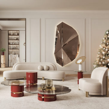 Luxurious living room featuring modern beige sofas, a matching armchair, and red side tables. A large, geometric bronze wall sculpture is the focal point, illuminated from behind. A decorated Christmas tree stands in the corner, adding a festive touch.