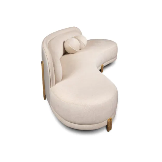Contemporary Curved Velvet Sofa A modern, beige, curved sofa with a unique, semi-circular design. The sofa has a smooth fabric finish and is supported by gold-toned metal legs. There is a matching cylindrical bolster pillow resting on the seat.