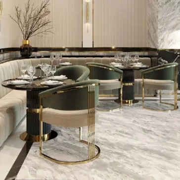 Contemporary Lacquered Round Bistro Dining Set A luxurious, modern dining area features a mix of cream-colored, tufted banquette seating and plush, green velvet chairs with gold accents. The **Contemporary Lacquered Round Bistro Dining Set** and marble flooring complement the elegant ambiance, enhanced by minimalist wall decor and a vase of branches.