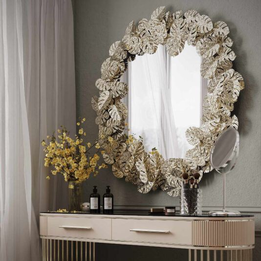 Elevate your luxurious vanity setup with the Contemporary Tropical Leaf Round Mirror, adorned with stunning gold leaf-shaped decorations. This chic contemporary vanity table neatly organizes makeup brushes, cosmetics, and a small round mirror. A vase filled with vibrant yellow flowers injects a burst of color, while sheer curtains gently diffuse light, creating an atmosphere of tropical elegance.