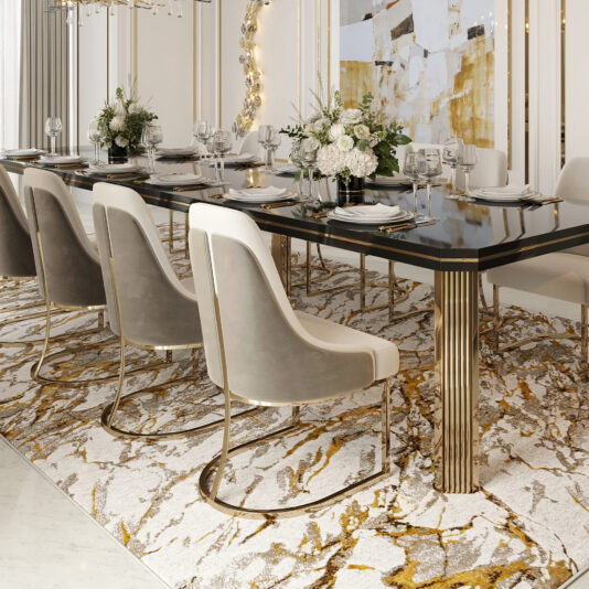 A luxurious dining room showcases a long, black table adorned with gold accents, encircled by eight Contemporary Two-Tone Dining Chairs in beige and gold. The table is elegantly set with plates, glasses, and white floral centerpieces. Overhead, a modern chandelier illuminates the space while abstract artwork enhances the walls.