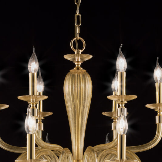 Hand Blown Gold Sheen Glass Chandelier A close-up view of the Hand Blown Gold Sheen Glass Chandelier reveals its elegance with multiple curved arms and lit candle-like bulbs. The chandelier features a chain link for hanging and is set against a dark background, which highlights its intricate design and warm glow.