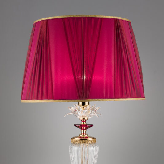 Luxury Table Lamp With Crystal Flower Detail Introducing the Luxury Table Lamp With Crystal Flower Detail, featuring a vibrant red lampshade. The base is adorned with intricate gold accents and a stunning crystal flower detail, exuding elegance and sophistication. Set against a plain gray background to keep all attention on the lamp's exquisite design.
