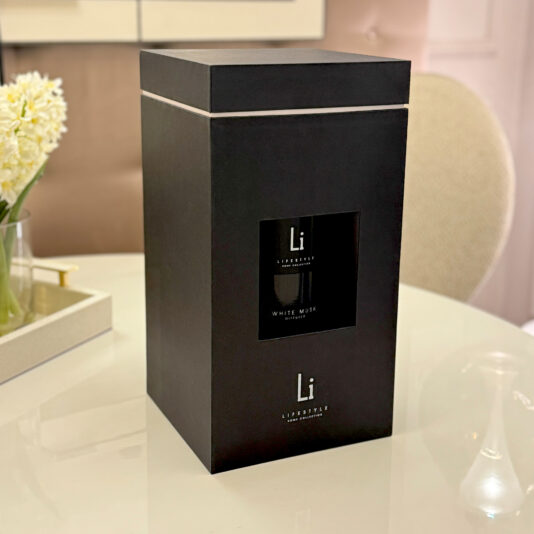 A large, elegant black gift box with a small window revealing the extra-large Luxury White Musk Room Diffuser labeled 