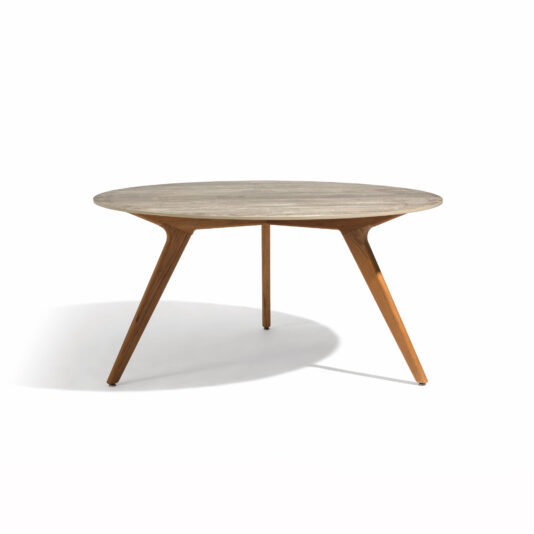 The centerpiece of the Round Outdoor Dining Set With Teak Chairs is a round wooden table featuring a smooth, light brown surface. It stands on three slender, tapered legs that angle outward, offering a minimalist and modern design. The background is plain white.