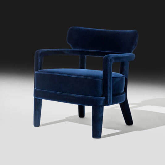 The Contemporary Small Velvet Occasional Chair showcases a minimalist design with smooth lines and rounded edges, featuring a contemporary navy blue velvet cushioned seat and backrest set against a gradient black-to-white background.