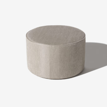 High End Round Pouffe The High End Round Pouffe, upholstered in beige fabric with a smooth surface and precise stitching, is displayed on a white background. It casts a subtle shadow to the right.