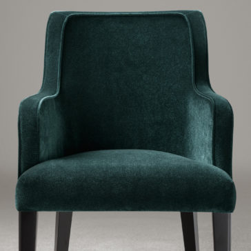 High End Occasional Velvet Armchair A luxurious High End Occasional Velvet Armchair in dark green features curved armrests and a high backrest. The chair, with its black wooden legs, is set against a plain grey background. The soft velvet fabric enhances its elegant and comfortable appearance.
