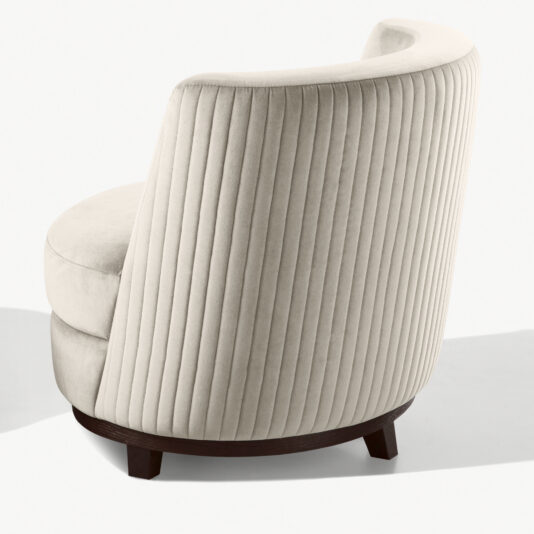 A rear view of the Quilted Occasional Chair with Swivel Base showcases its modern off-white fabric upholstery, characterized by a curved, ribbed design and plush cushioning. The chair features sleek dark wooden legs and an armless structure, making for a contemporary and sophisticated look.