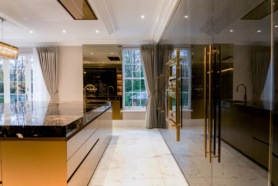Luxury Family Kitchen deep rich tomes and marble tops, glossy cabinet doors and gold accents