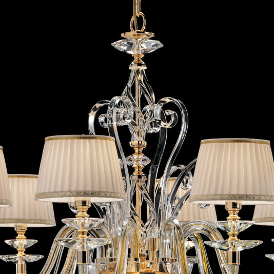 Classic Style Chandelier With Swarovski® Crystals The Classic Style Chandelier With Swarovski® Crystals boasts a luxurious design with gold accents, cream lampshades, and elegantly curved elements set against a black background.