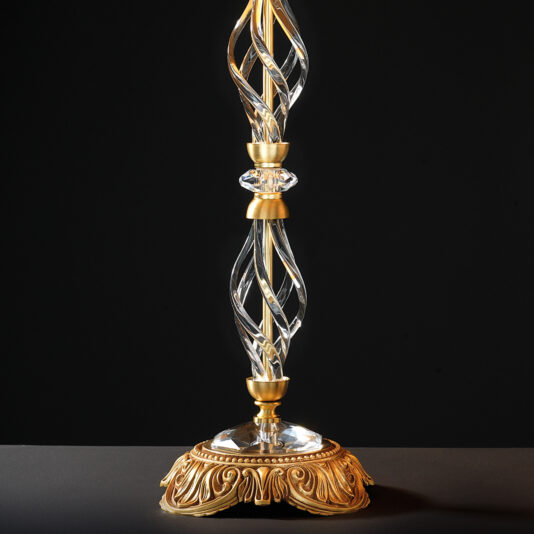A Classic Style Twisted Table Lamp featuring an ornate golden finish, a twisted glass column, and an intricate decorative base. Set against a dark background, it highlights its elegant design beautifully.