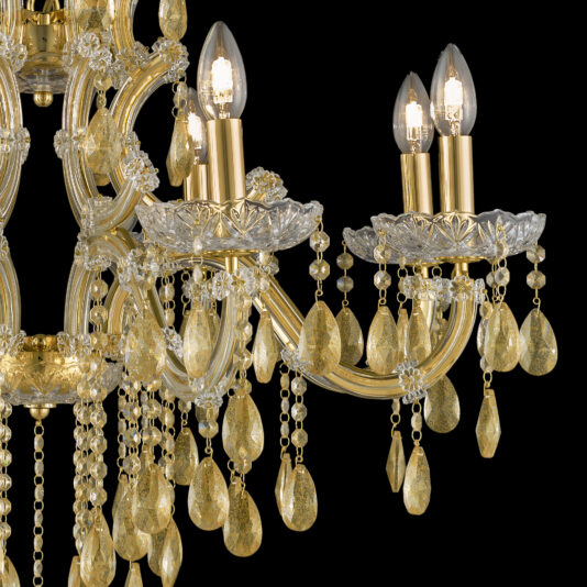 Gold Leaf Glass Chandelier An up-close shot of the Gold Leaf Glass Chandelier reveals its golden accents and clear, teardrop-shaped crystals adorning the arms. The chandelier's lit candle-like bulbs illuminate the individual beads and crystals, reflecting light to create a luxurious and elegant ambiance.