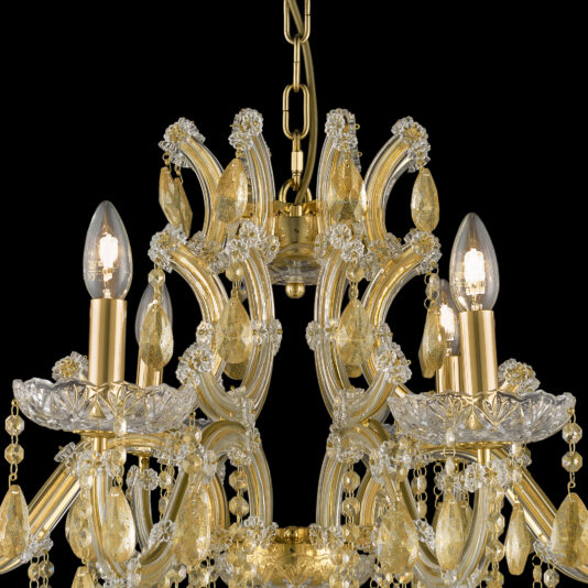 Gold Leaf Glass Chandelier An elegant Gold Leaf Glass Chandelier featuring intricate detailing and adorned with numerous teardrop-shaped crystal ornaments. It has four lit candle-style light bulbs on ornate holders, all suspended by a gold chain against a black background.