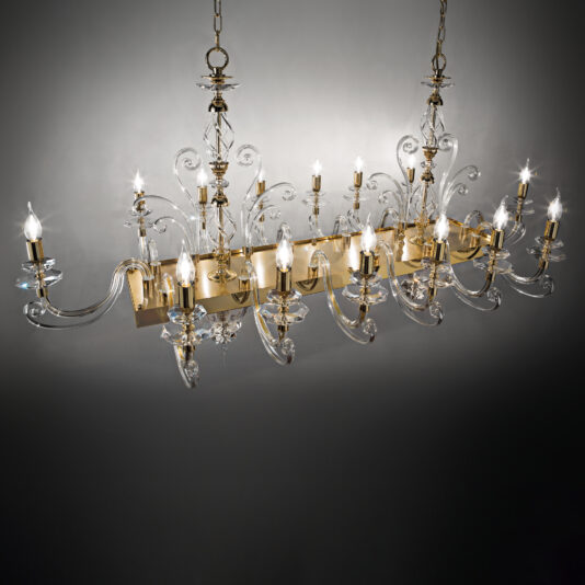 The Rectangular Classic Candle Style Chandelier boasts a sophisticated design with multiple swirling glass arms, each showcasing a traditional candle-style bulb. This fixture is adorned with intricate glass detailing and features an elegant gold frame, suspended by dual chains. It casts a refined ambiance against a neutral background.