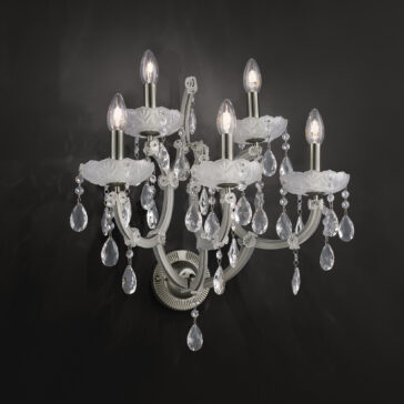 The Satin Glass Classic Style Wall Light is a sophisticated wall-mounted chandelier that features five candle-like bulbs and satin glass accents. This classic style fixture showcases delicate crystal decorations hanging from ornate arms, set against a dark background, creating a striking contrast and an elegant ambiance.