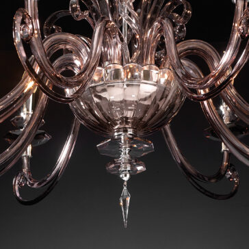 Smoked Glass 8 Arm Chandelier Close-up view of the elegant Smoked Glass 8 Arm Chandelier featuring intricate curved arms and a crystal ornament hanging from the center. The chandelier's reflective surface gleams beautifully against the dark background, highlighting its shimmering details.