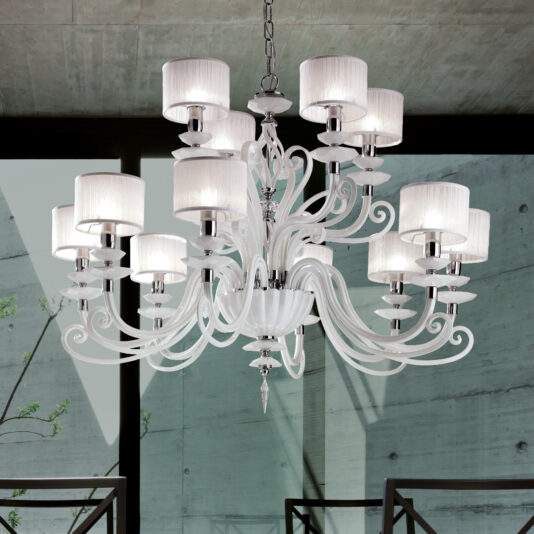 The White Glass Modern Chandelier With Shades hangs from a chain in a room with concrete walls and large windows. Featuring multiple curved arms adorned with white lampshades, this chandelier's design blends elegant curves with sleek lines, achieving a contemporary yet classic look.