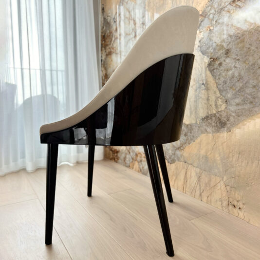 side of a modern Art Deco dining chair in ivory and dark wood close up