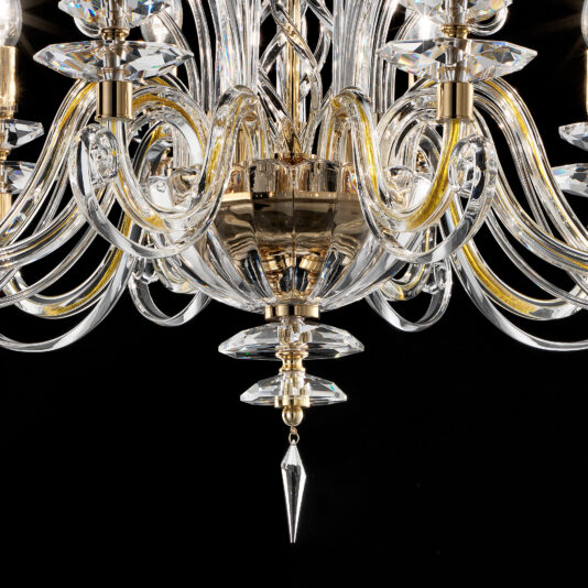 Close-up of the Candle Style Chandelier with intricately curved glass arms and crystal details, featuring a central gold-colored fixture. The chandelier elements glisten against a dark background, highlighting its luxurious design.
