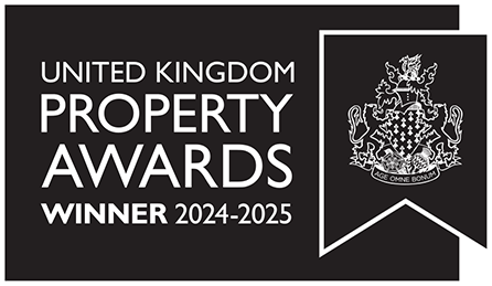 A black and white logo featuring the text "United Kingdom Property Awards Winner 2024-2025" on the left. On the right, there is an ornate crest with lions and a banner bearing the motto "DIEU ET MON DROIT.