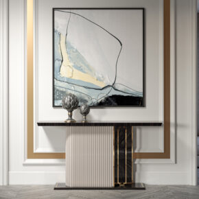 A stylish interior features a modern console table with two decorative vases underneath an abstract painting. The wall is adorned with elegant molding in white and gold accents, creating a sophisticated look.