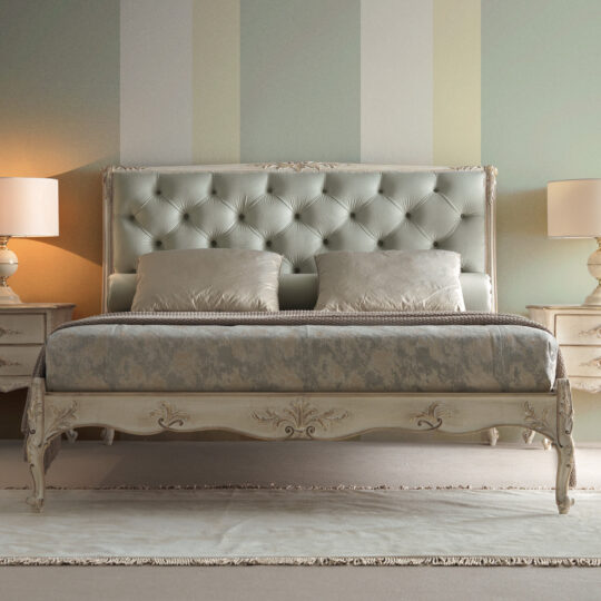A luxurious bedroom showcases a Classic Louis Style Button Upholstered Bed, complete with a button-tufted headboard and elegant patterned bedding. The room is complemented by two matching nightstands, each adorned with a lamp, and softly striped walls in pastel shades.