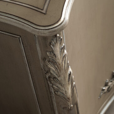 Close-up of an elaborate corner of the High End Rococo Inspired Sideboard, showcasing intricate leaf carvings and a distressed finish. The edge is gently curved with a smooth, aged appearance that accentuates the exquisite craftsmanship.