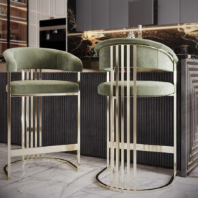 Two modern bar stools with green velvet seats and gold metal frames stand in front of a stylish kitchen counter with a geometric pattern. The kitchen has dark marble accents and glossy cabinets, and the floor is covered with white marble tiles.