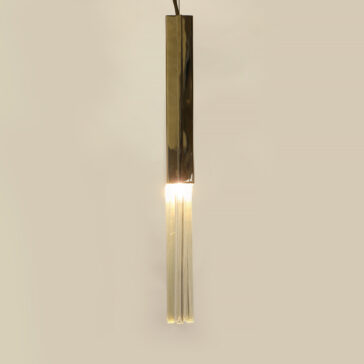 Slim Glass Drop Pendant Light The Glass Drop Pendant Light features a contemporary design with a sleek gold cylindrical cover and transparent tubular extensions, casting a warm glow against a neutral beige background.