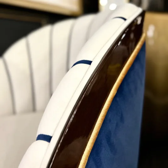 Close-up of the Art Deco Style Occasional Chair, showcasing its sophisticated wooden frame, white upholstery with blue stripes, and rich deep blue fabric on the backrest. This design captures elegant curves and a plush texture in true Art Deco fashion.