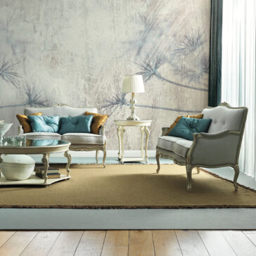 A stylish living room showcases a pair of vintage armchairs, a matching loveseat, and the luxurious High End Rococo Style Sofa. The seating is adorned with blue and gold cushions for added elegance. A table lamp rests on a side table, and a large decorative wall mural complements the sophisticated ambiance.