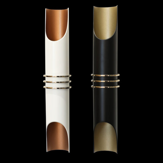 Two sleek and elegant wall sconces, set against a black background, epitomize modern design. The sconce on the left is white with copper accents, while the one on the right boasts a black finish with gold touches. Each stunning Modern Vertical Wall Light includes two metallic bands at the center, enhancing its sophisticated appeal.