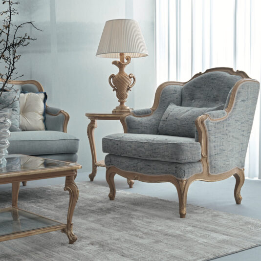 Rococo Style Armchair Create a cozy living room atmosphere with the Rococo Style Armchair featuring blue-gray upholstery and light wood accents. Add matching cushions, a side table, and an ornate lamp to enhance the classic Rococo appeal. A glass coffee table pairs beautifully with the neutral tone rug, completing this elegant setting.